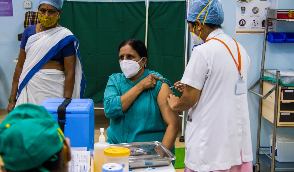 Women receiving a vaccine by a medical professional 